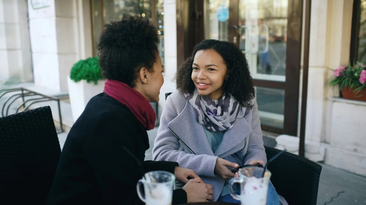 Two women talking at an outdoor café